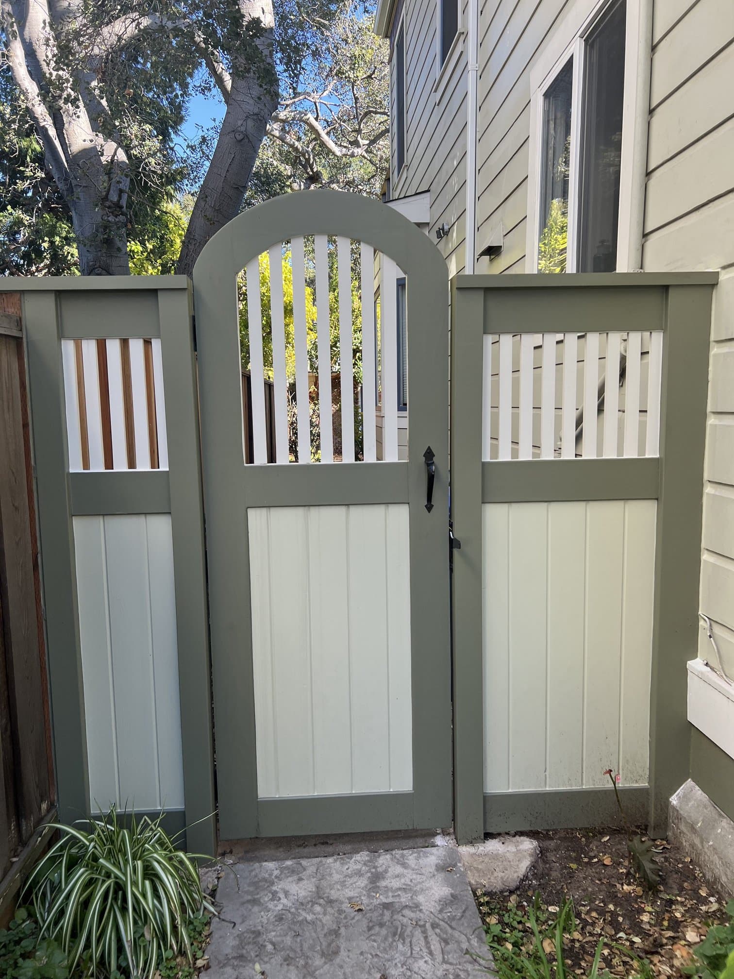 Arched wood gate set in a two-tone horizontal fence