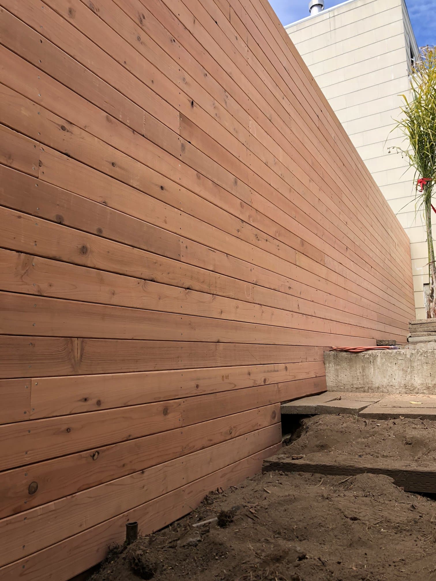 Cedar deck planks being laid across joists during backyard install