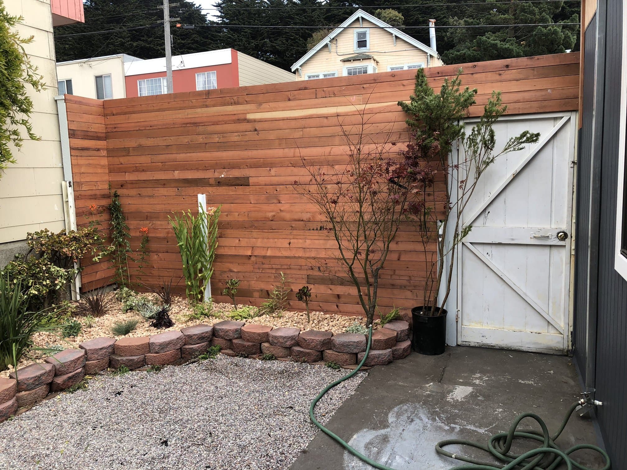 Horizontal fence above a concrete retaining wall and garden beds