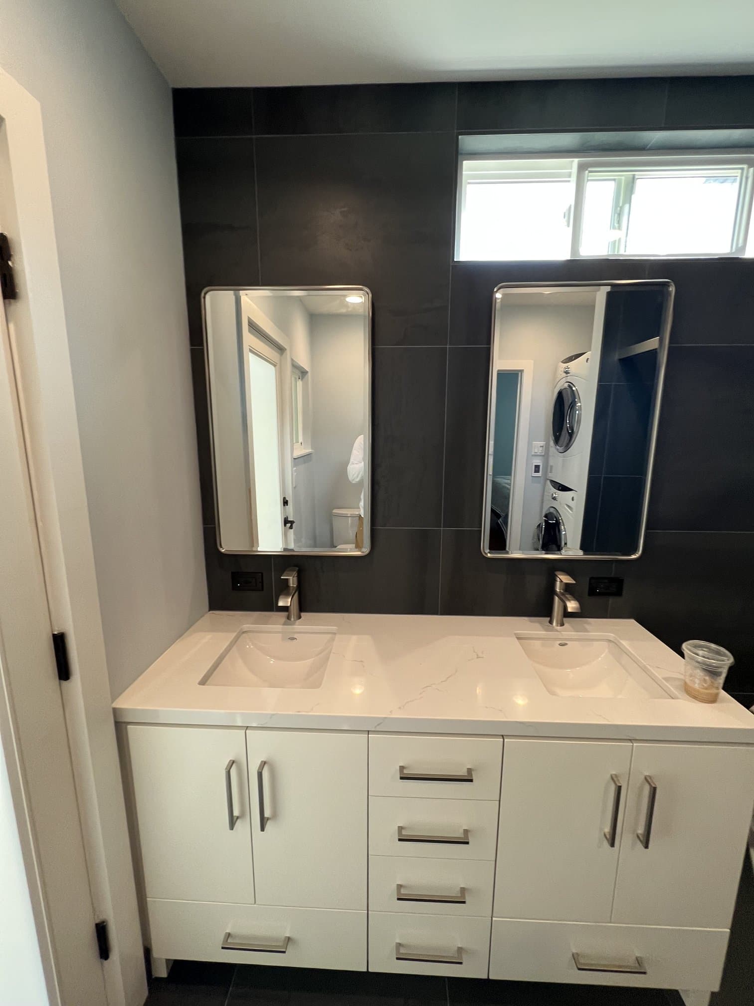 Double vanity with charcoal wall tile and matching mirrors