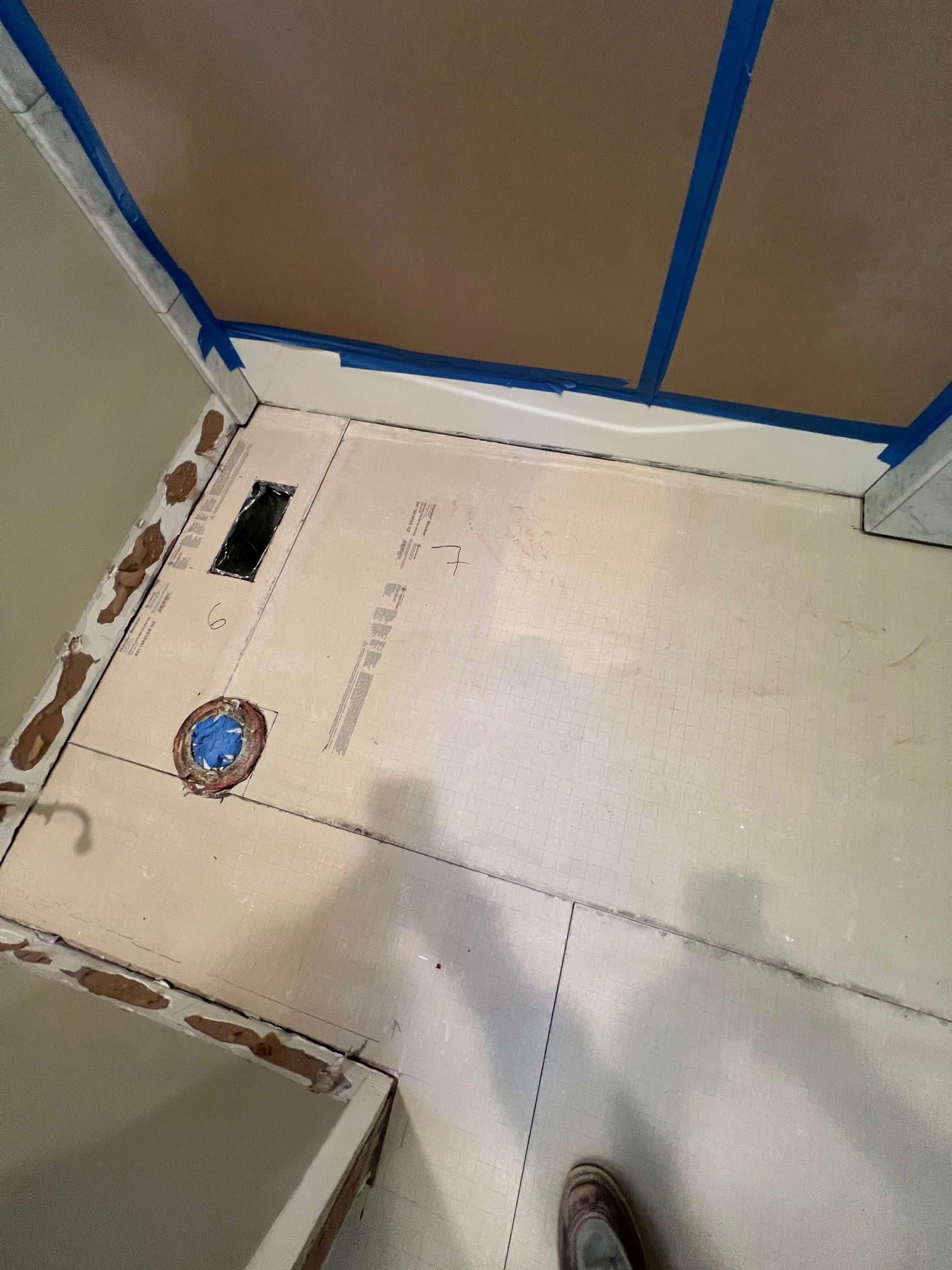 Cement board underlayment fitted over a bathroom subfloor before marble tile