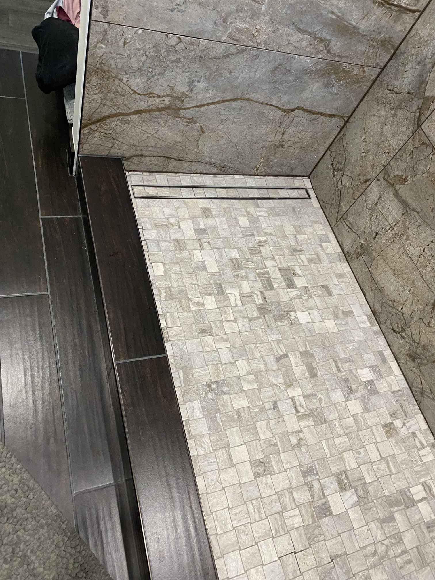 Shower mosaic floor with a linear drain during tile install