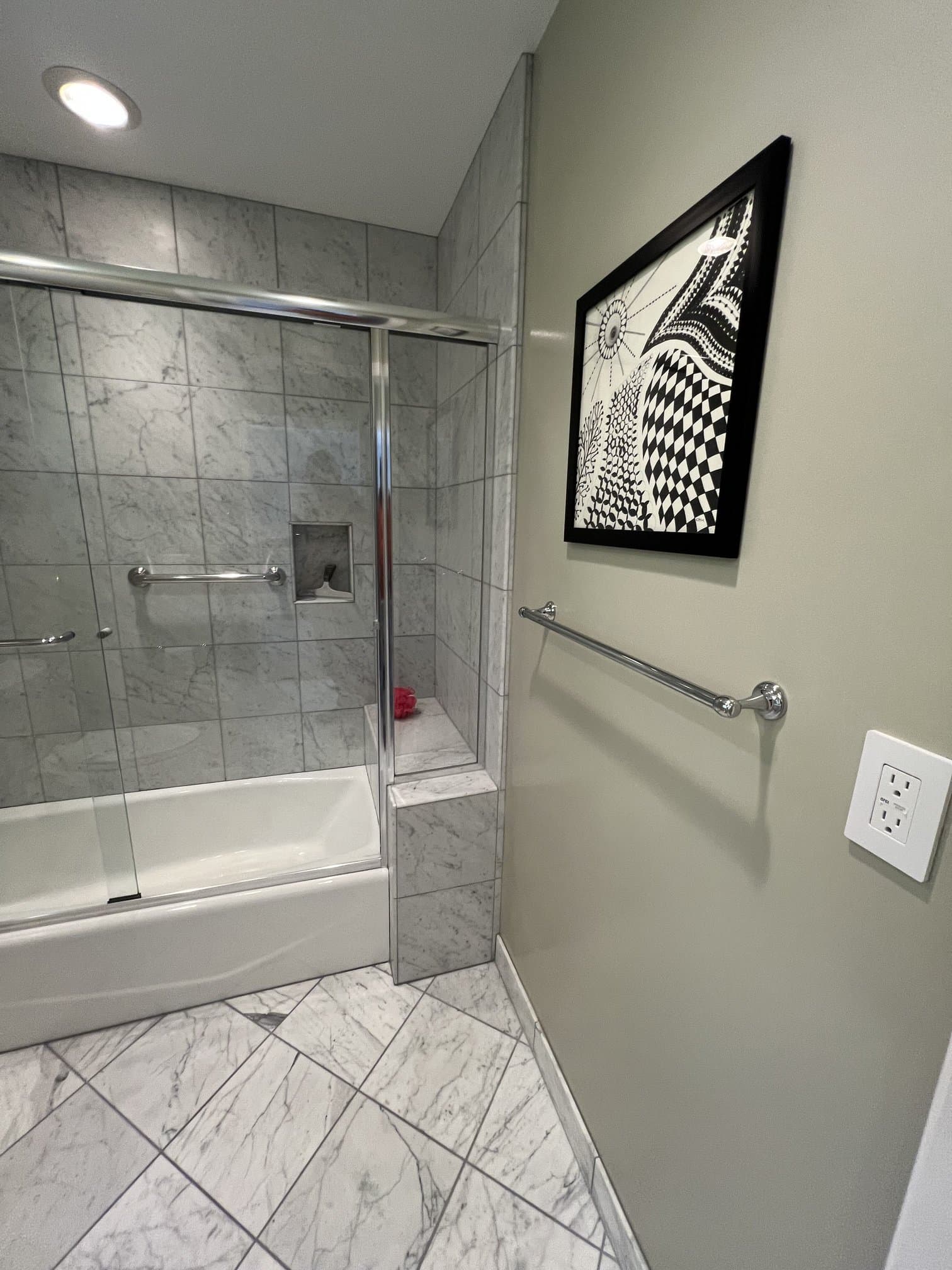 Tub and shower surround in marble tile with a recessed niche