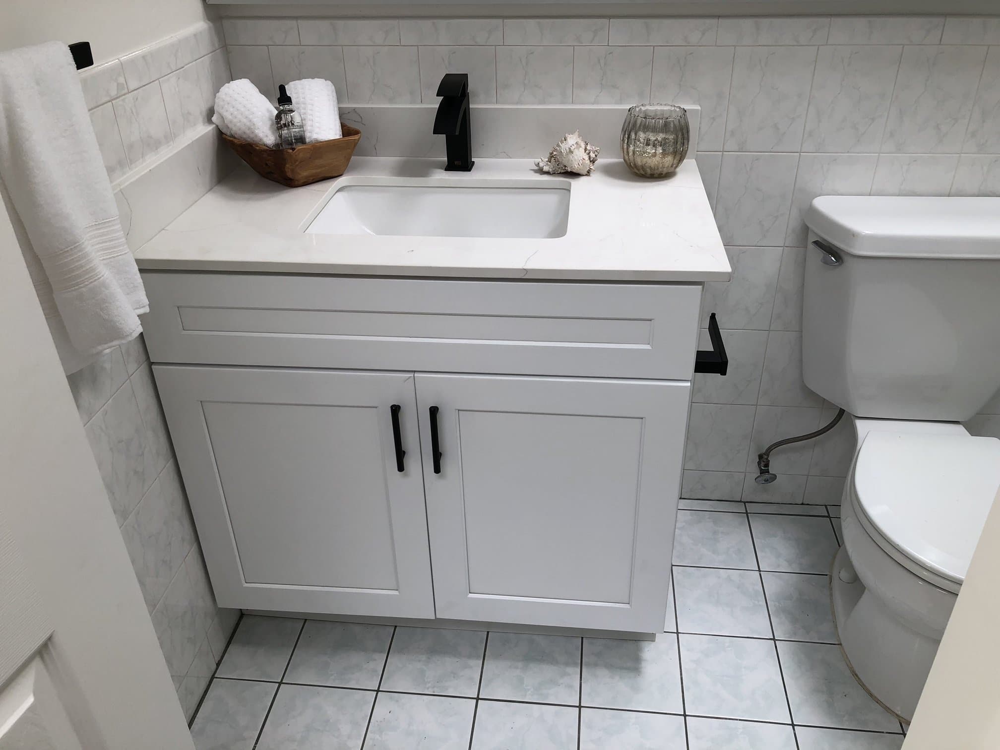 Bathroom vanity with marble tile floor and matching backsplash