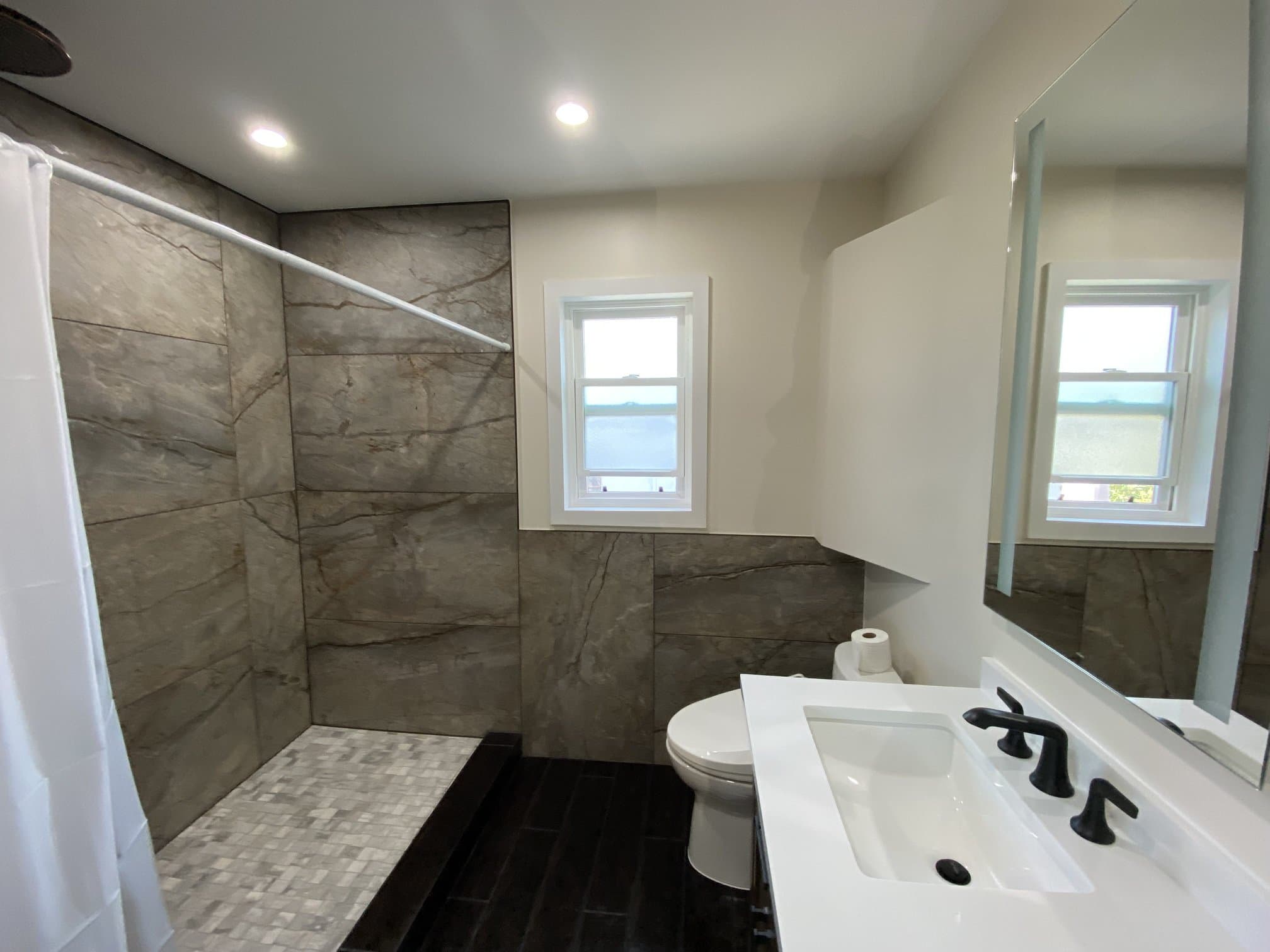 Walk-in stone-tile shower beside the bathroom vanity