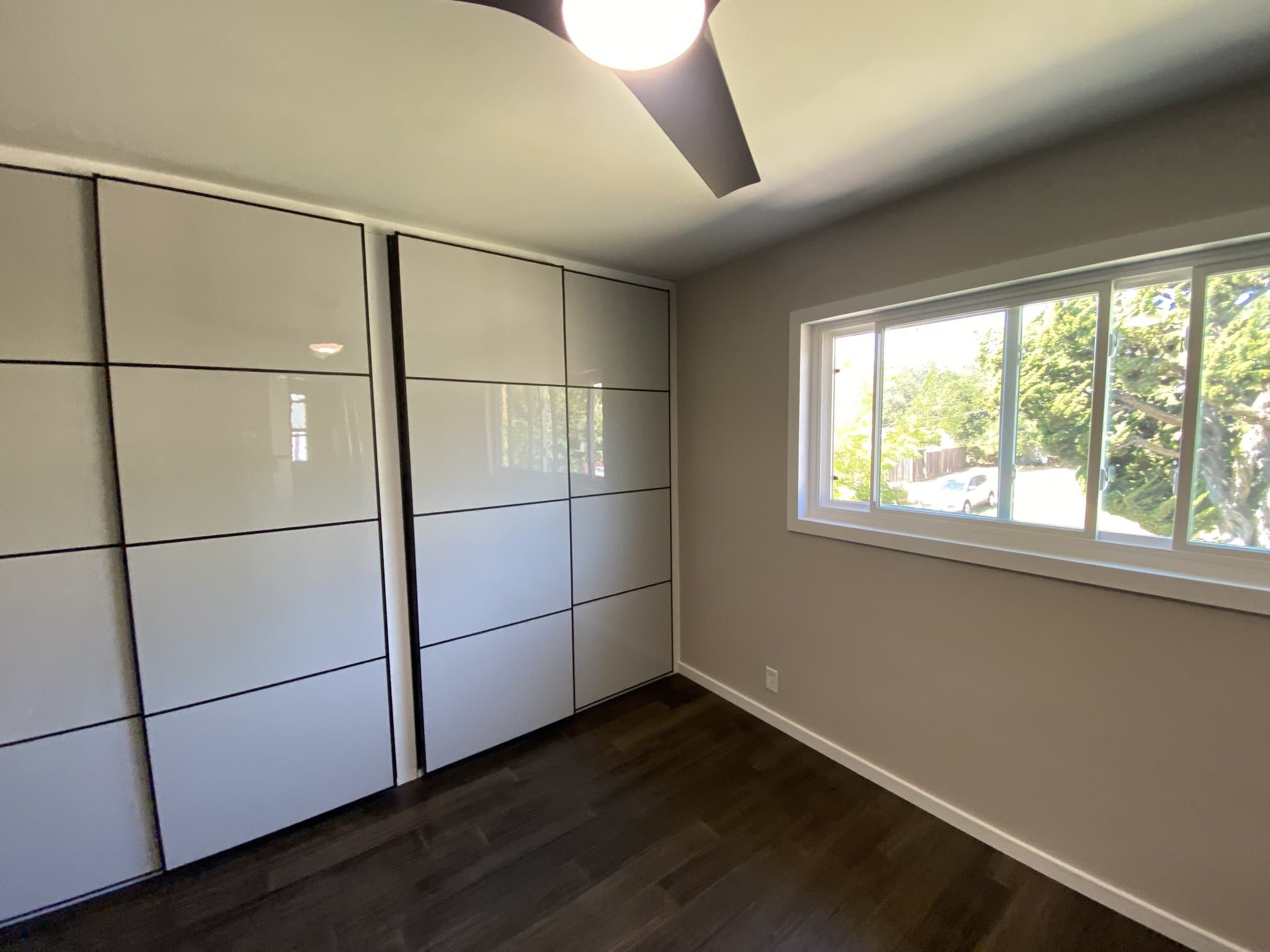 Bedroom with grid-style closet doors and wood flooring