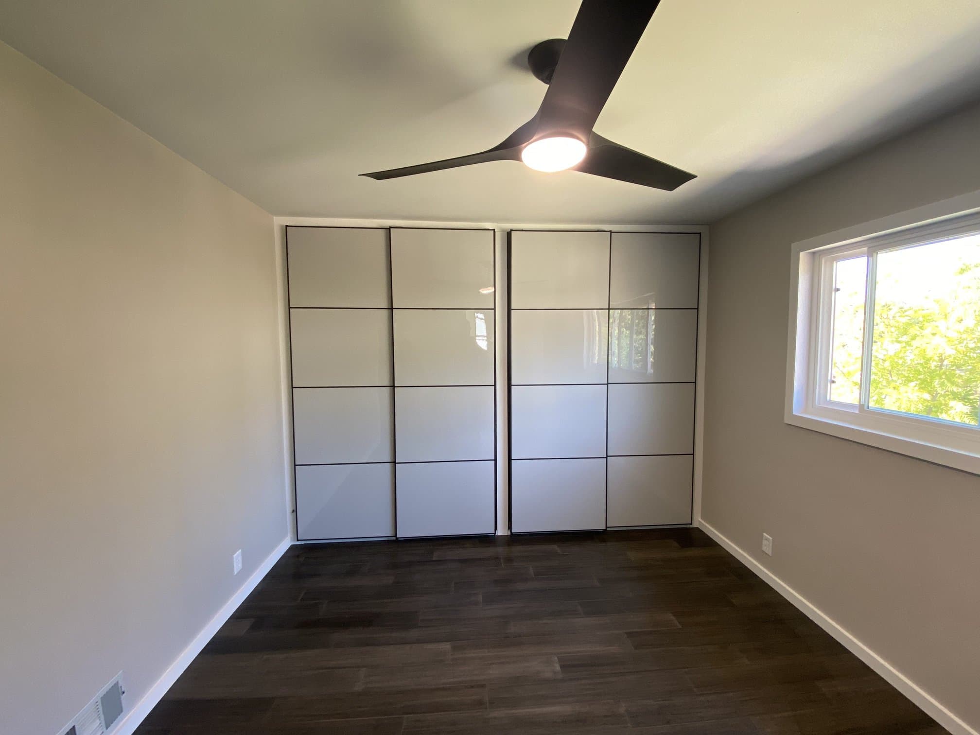 Bedroom sliding closet doors over dark flooring