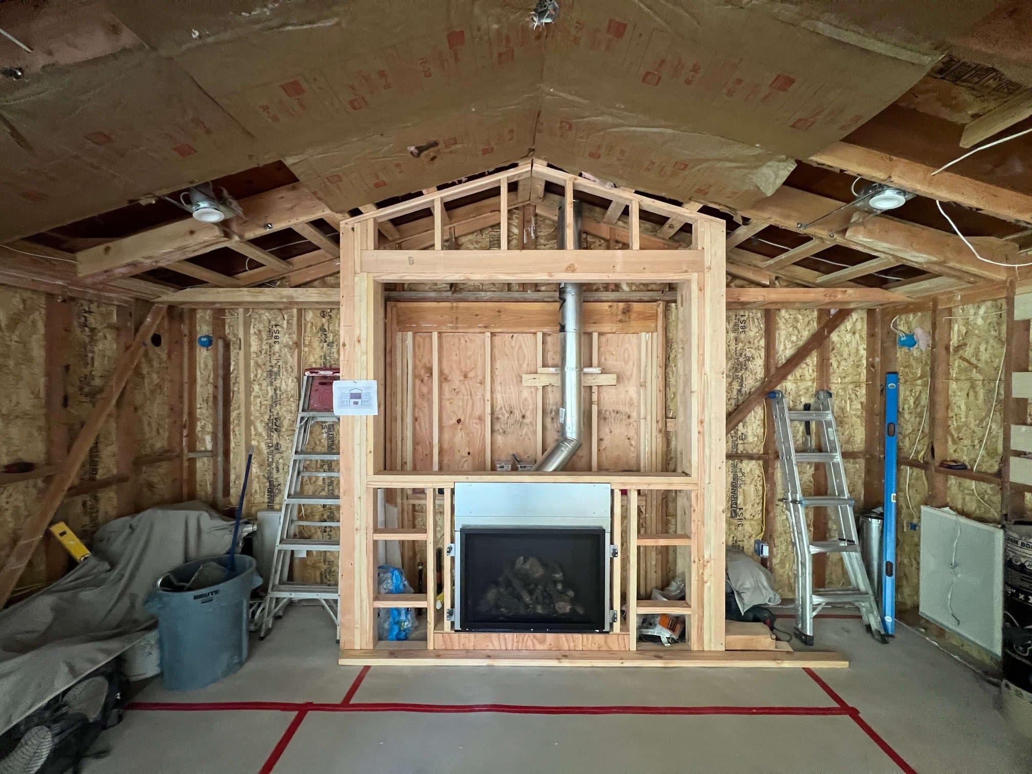 Framing for a custom built-in entertainment center with fireplace insert, TV niche, and side shelves