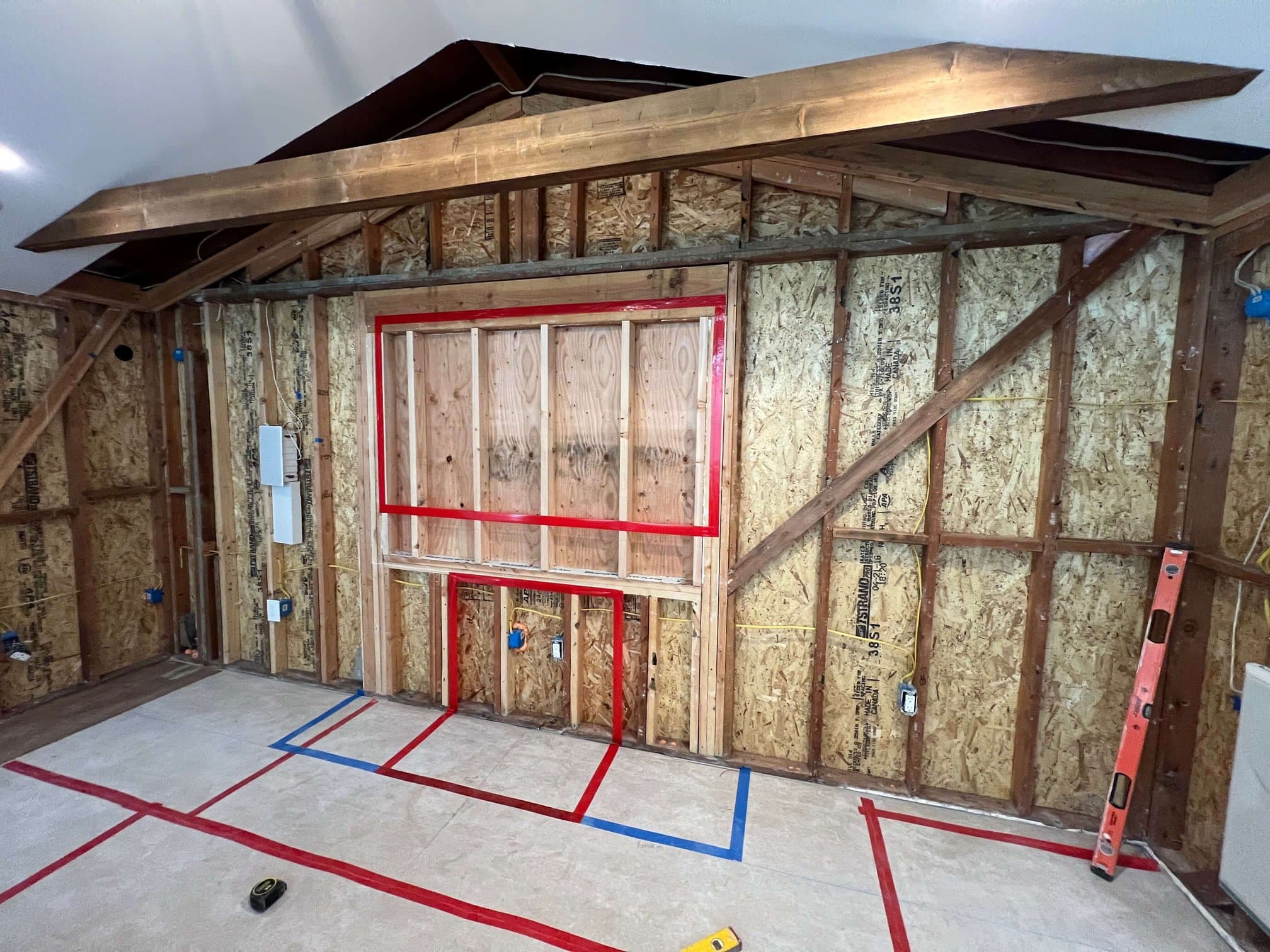 Layout for a custom fireplace and TV built-in taped out on an open stud wall