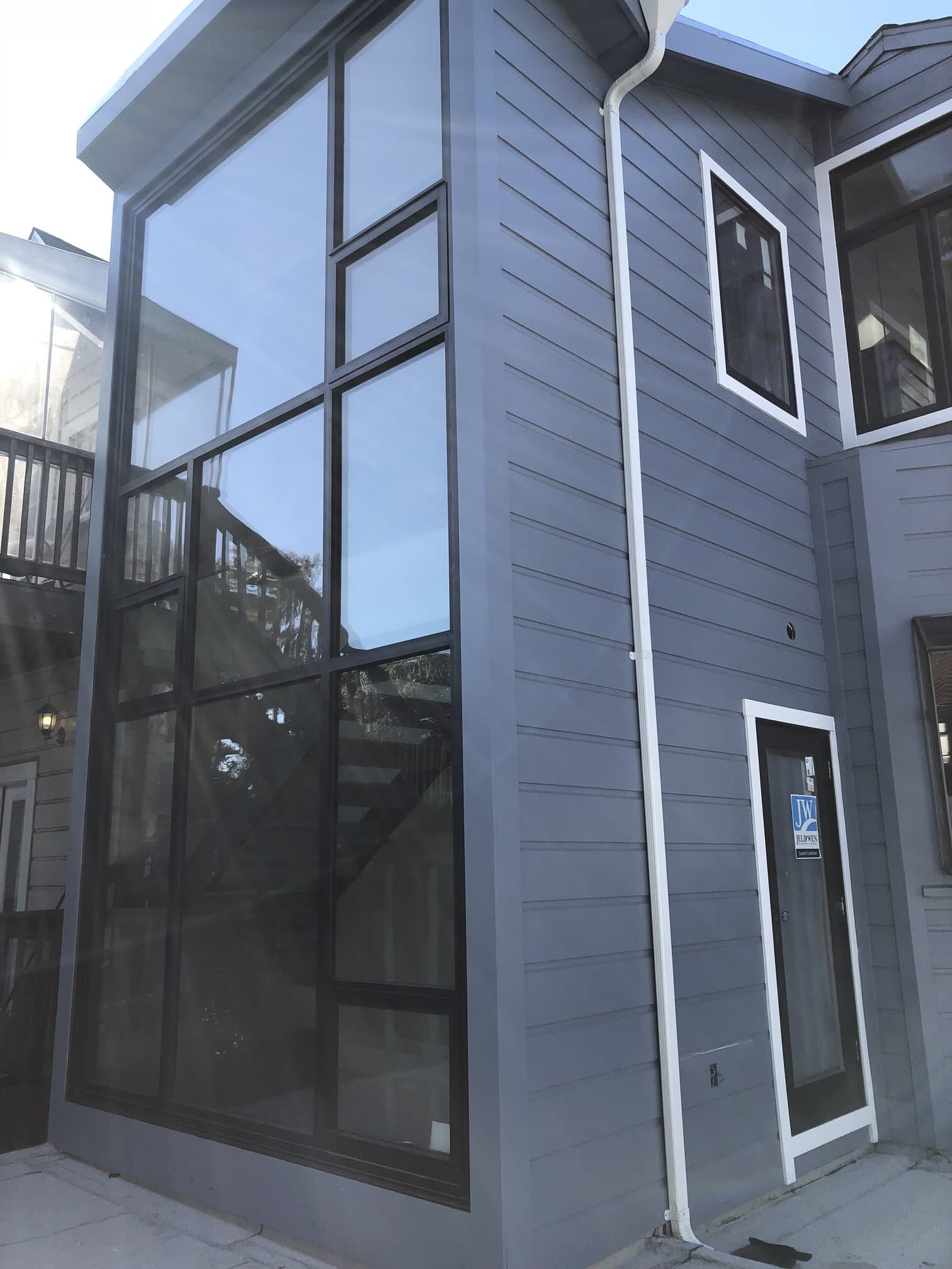 Dark vertical siding with a black-framed window wall
