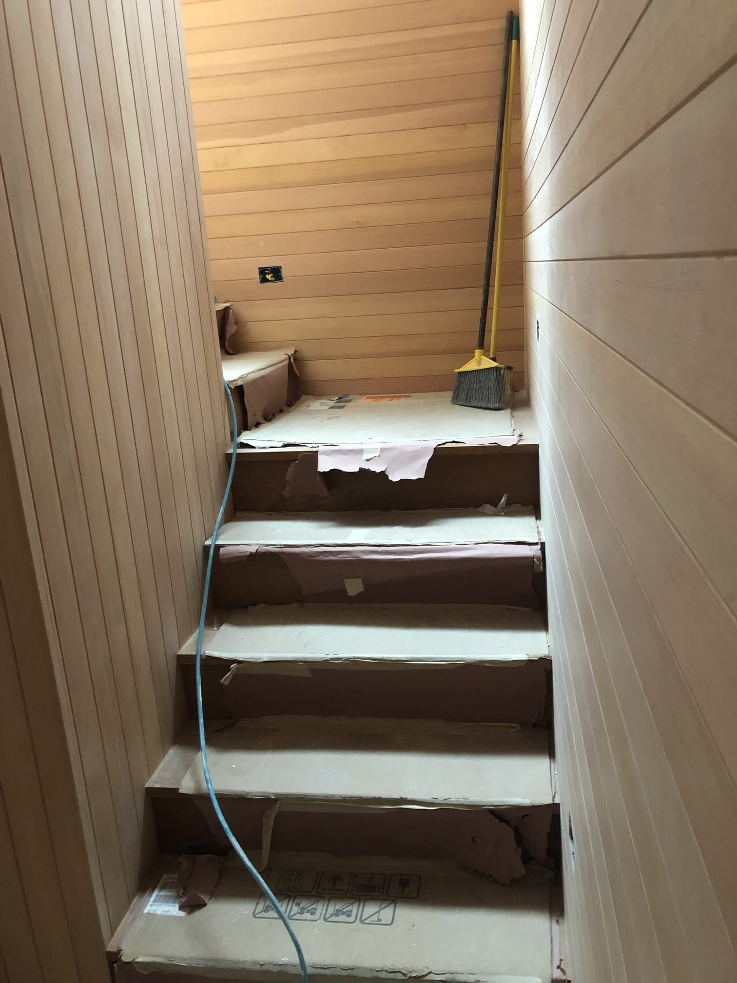 Hallway with wood plank walls leading to a stair run