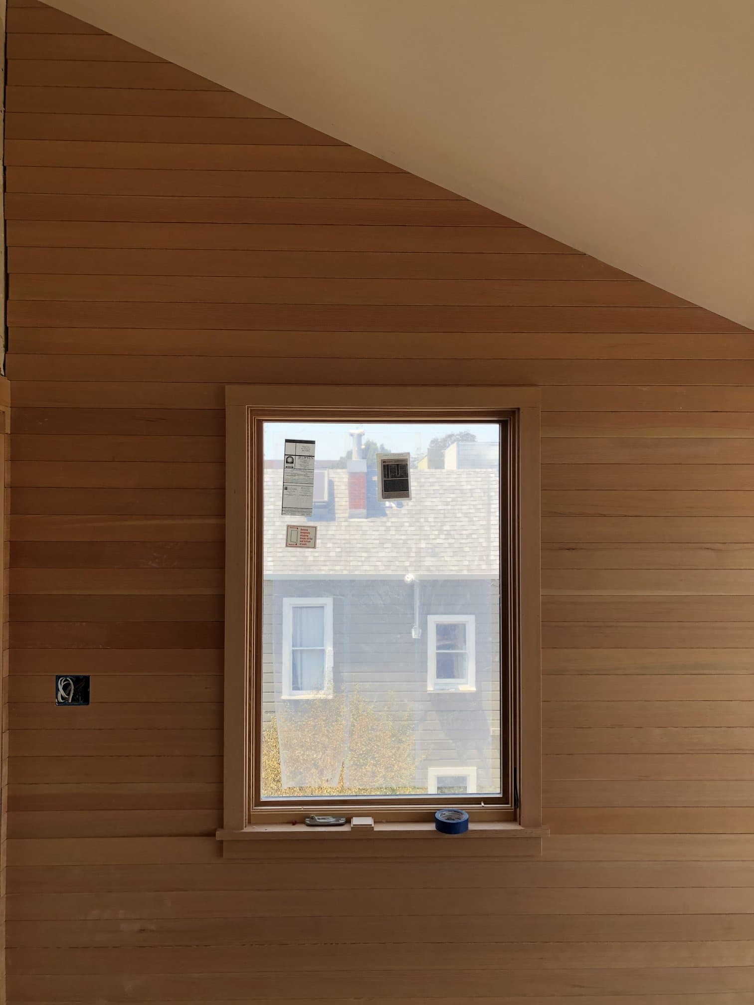 Interior vertical wood paneling beside a window install
