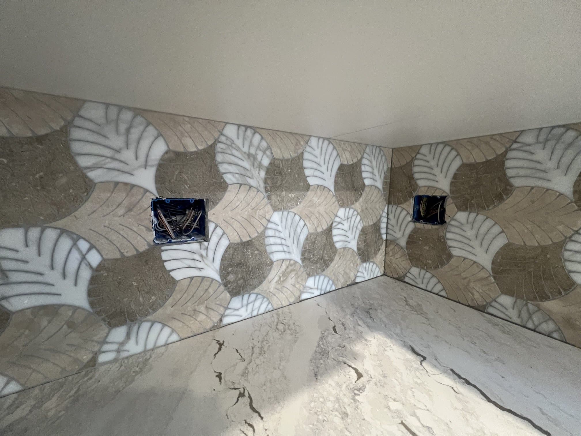 Leaf mosaic tile backsplash above a kitchen counter