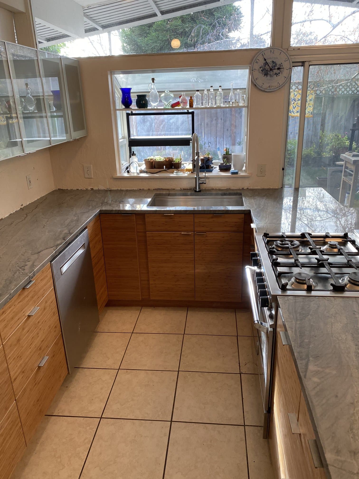 Kitchen sink run with stone countertop, bamboo base cabinets, and stainless faucet