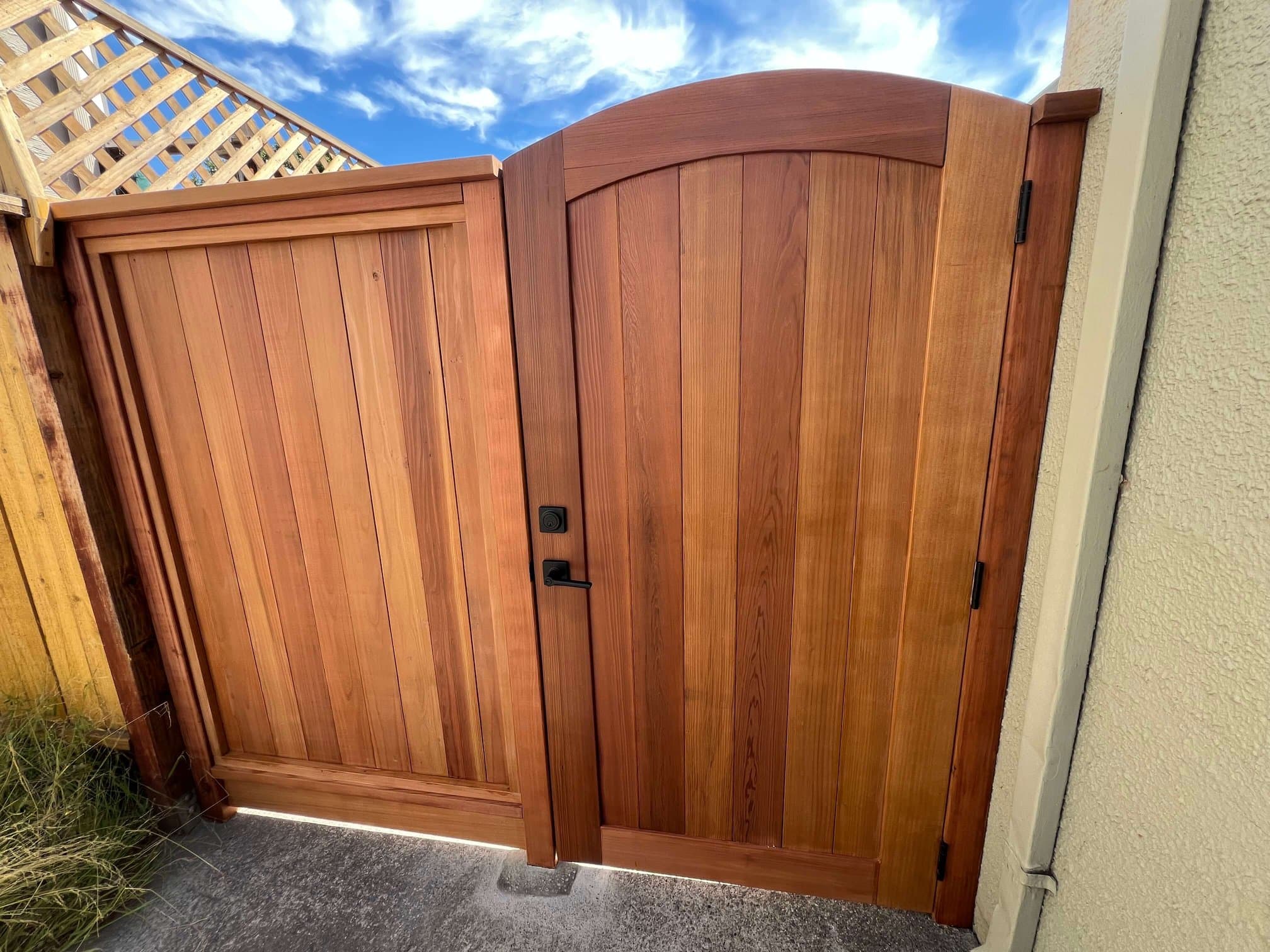Cedar fence and gate with black hardware, including a keypad on the arched pedestrian gate