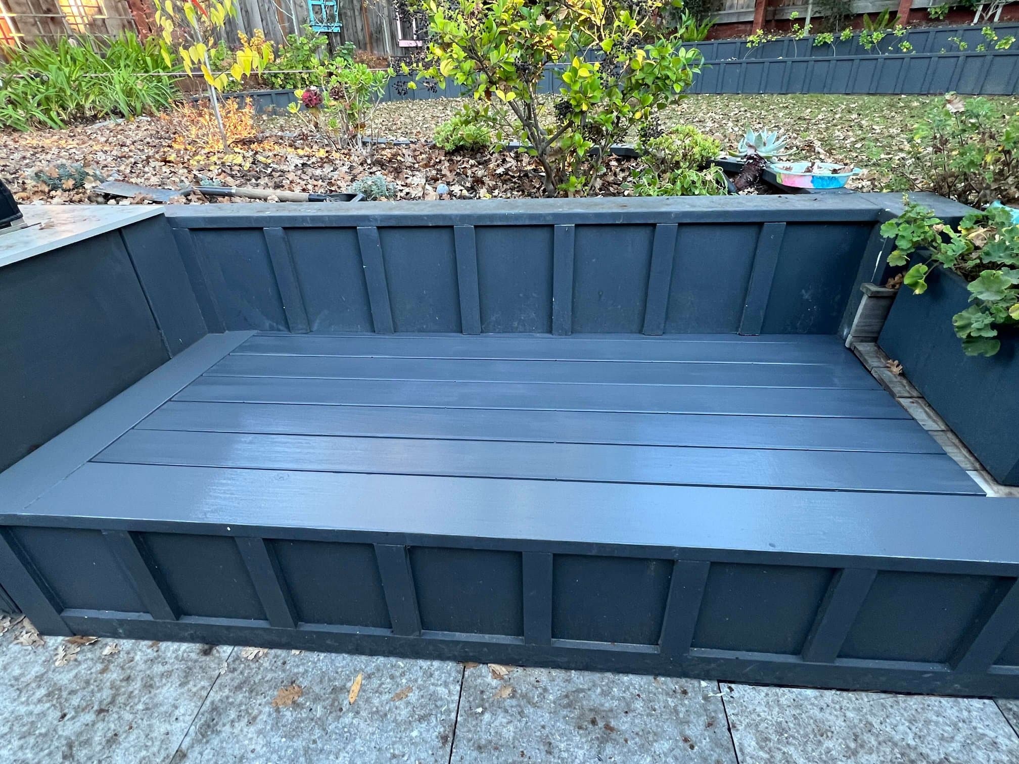 Front view of a custom paneled outdoor bench with an integrated planter