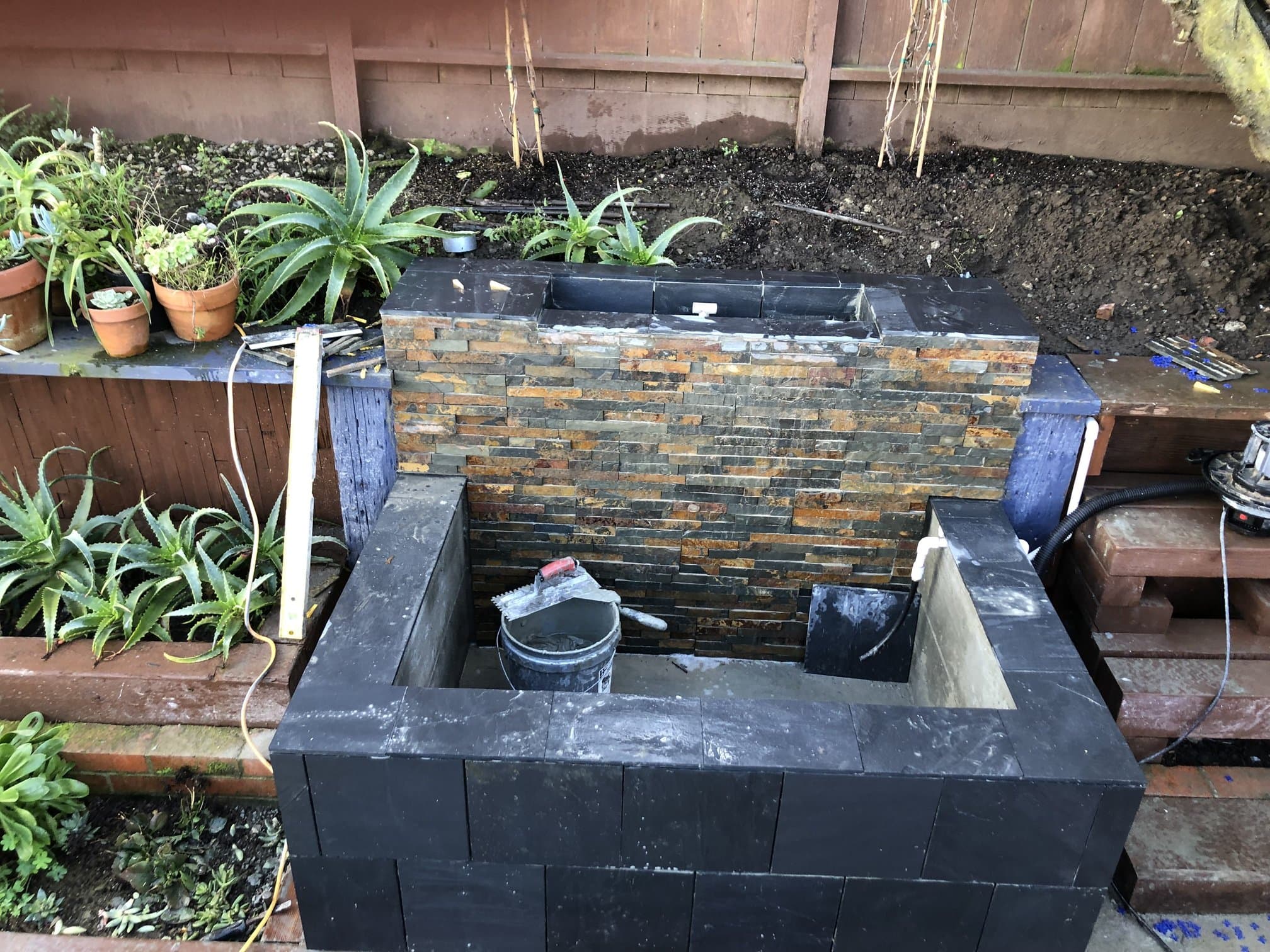Outdoor fountain finished in ledger stone and slate tile