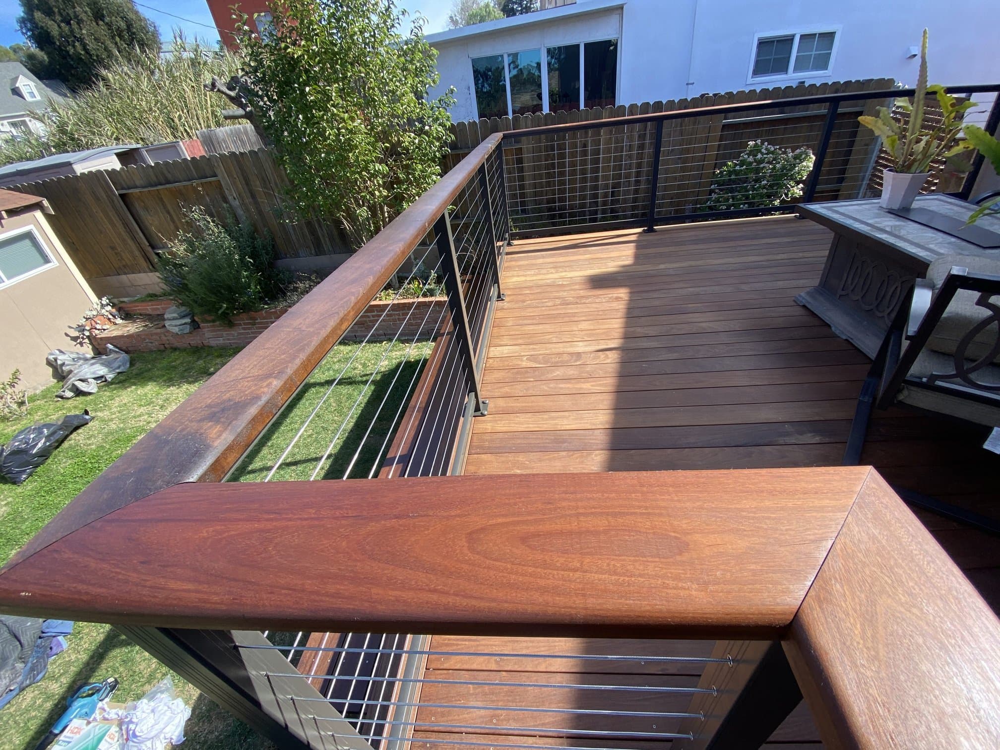 Wood deck edge with cable wire railing keeping the yard view open