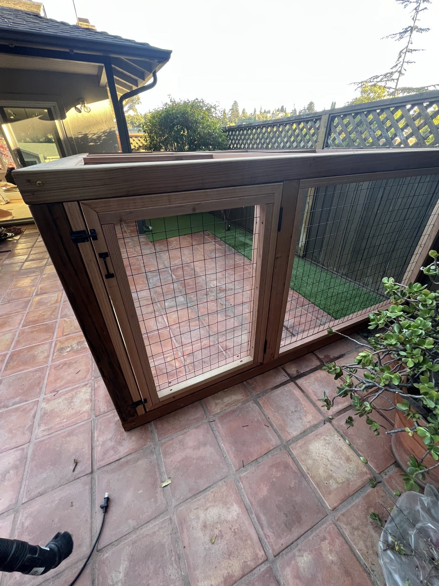 Outdoor wood-frame catio enclosure with wire mesh