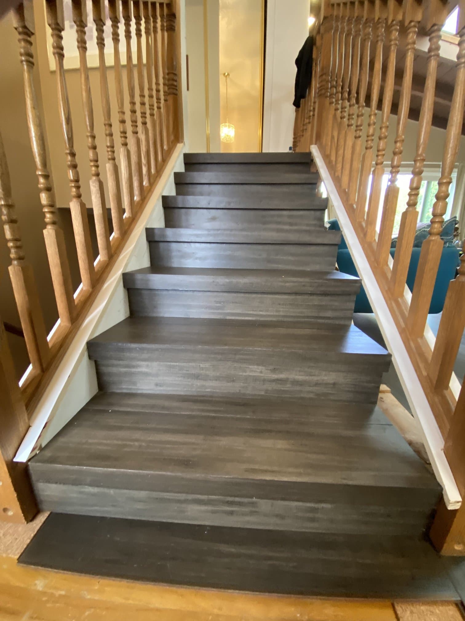 Staircase with dark treads, oak banister, and spindles