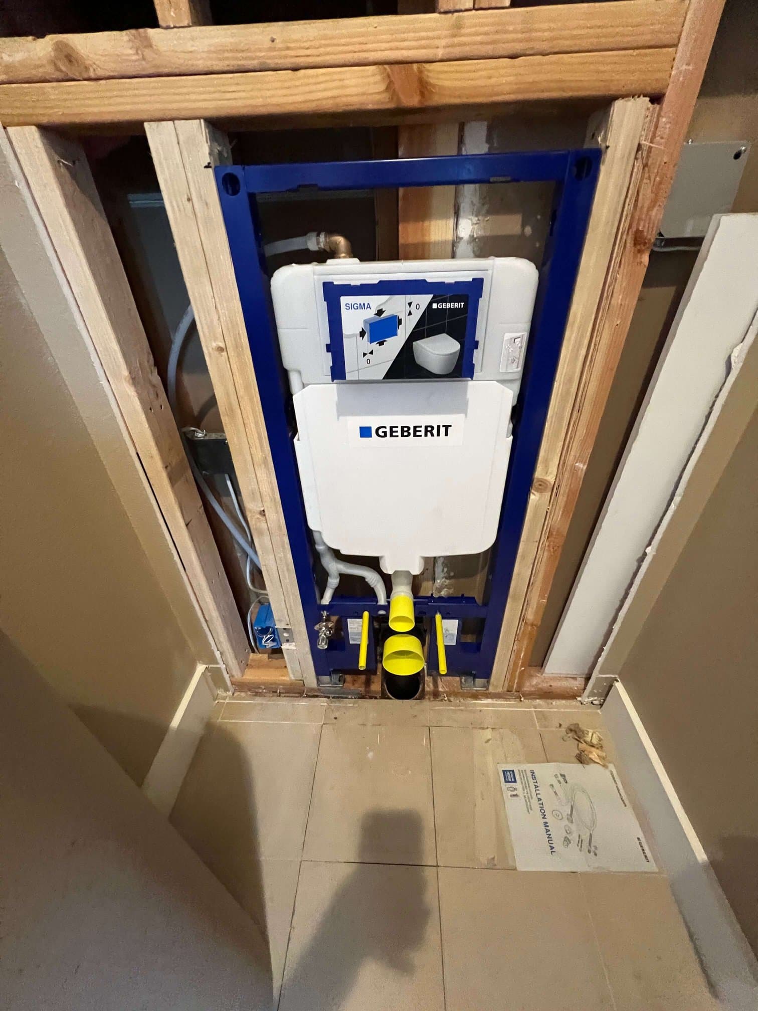 In-wall Geberit tankless toilet carrier installed in open bathroom framing